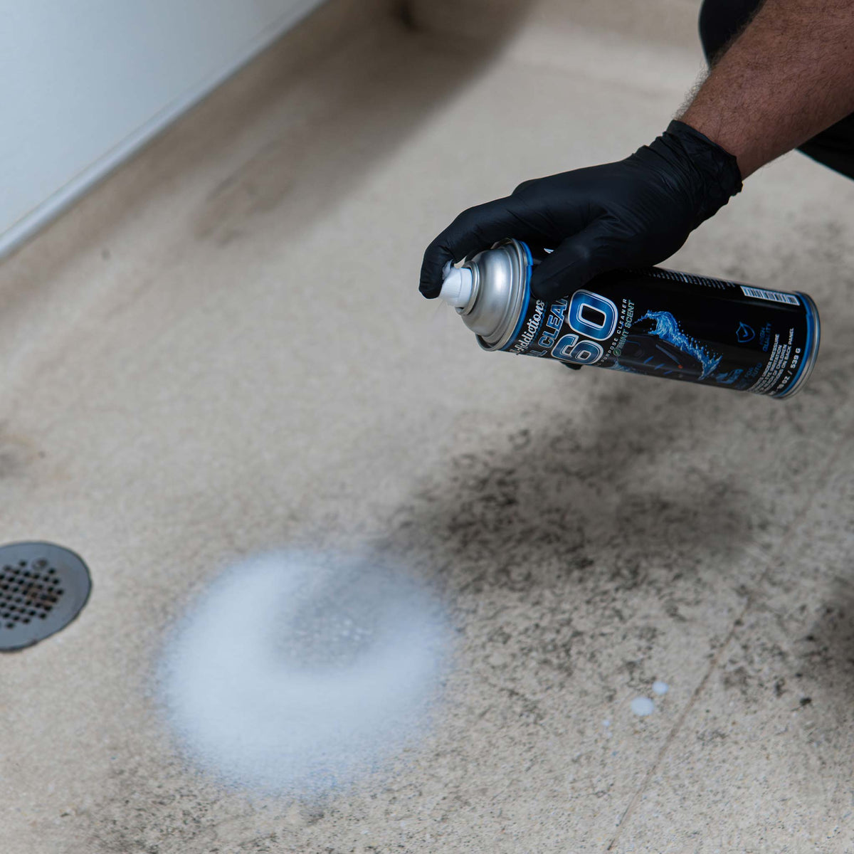Detail Addictions Total Clean 360 foaming cleaner sprayed on a stained bathroom floor near a drain
