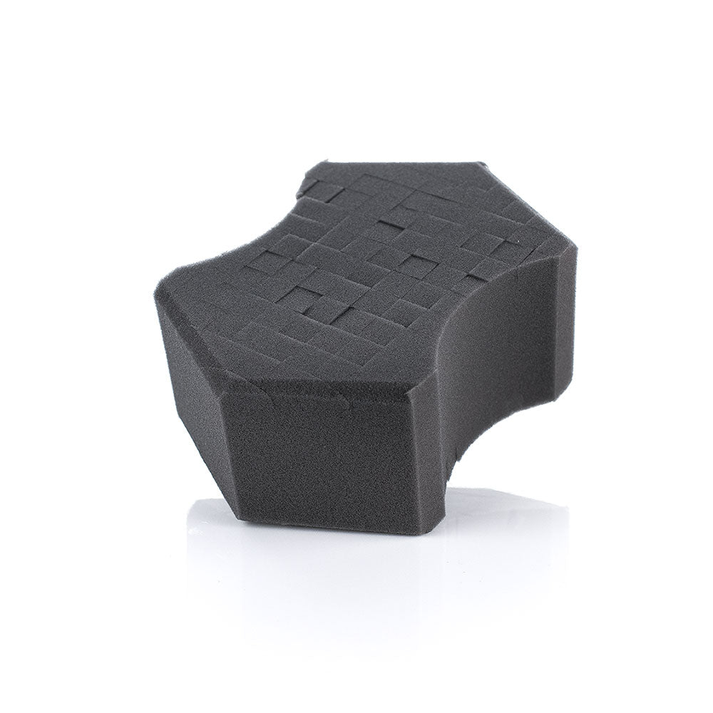Black foam sponge with textured surface on a white background