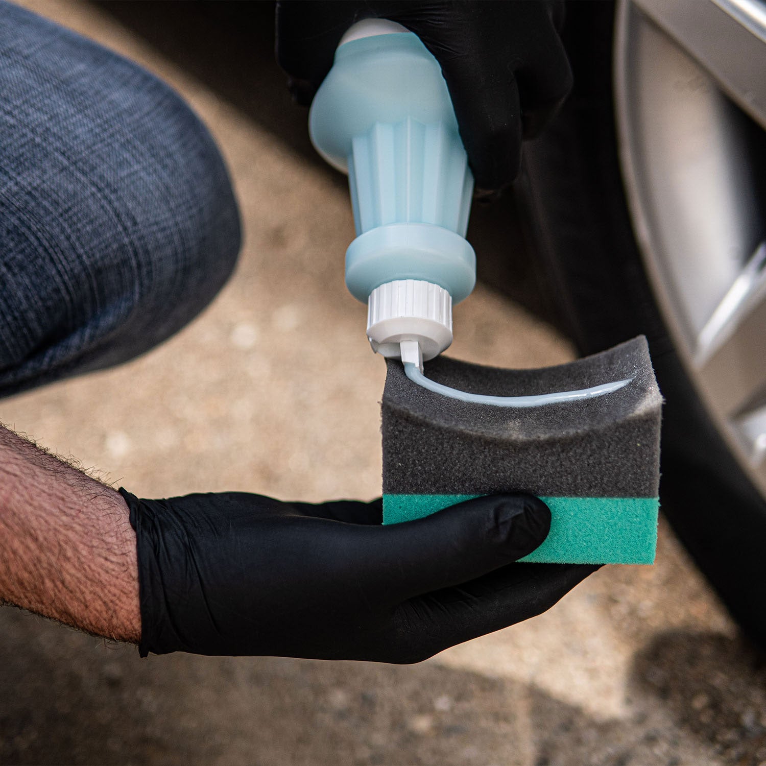 green-and-black-tire-dressing-applicator-getting-dressing-applied